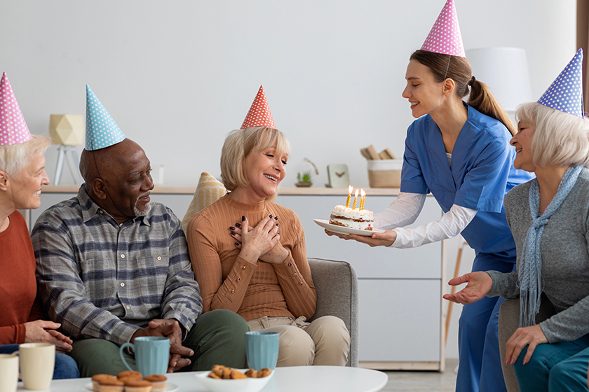 Elderly woman having birthday party at nursing home