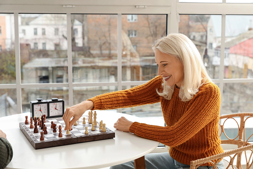 Mature woman with her husband playing chess