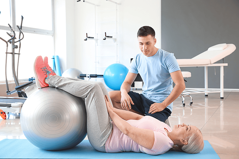 Physiotherapist working with mature patient 